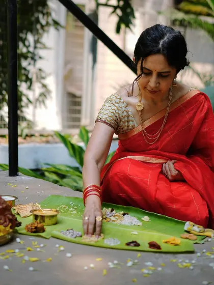 A moment of quiet enjoyment. Eating a Sadya is a personal journey of flavors. Here, a guest savors the meal, surrounded by the simple, earthy elements of the feast.
