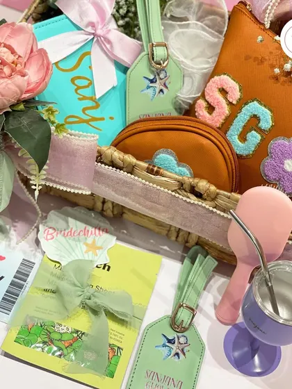 A closer look at the bachelorette hamper, showing the personalized pouches with chenille patch initials, custom luggage tags, and a salon voucher.