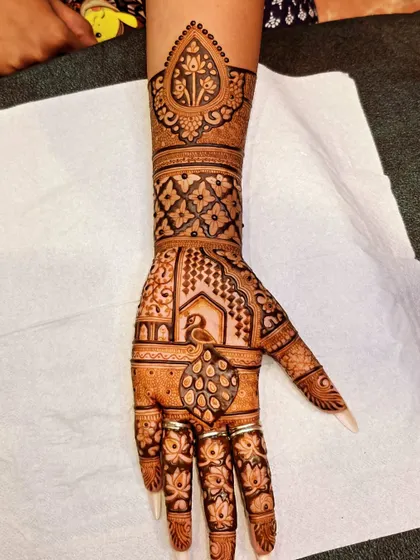 A single hand from the Teej special design, showing the intricate details of the peacock, the lotus motifs on the fingers, and the geometric patterns on the arm.
