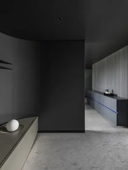 A view from the entrance foyer of 'A Hint of Azul', showing the transition from the curved bench to the dining area. The custom furniture pieces guide the path of movement through the space.
