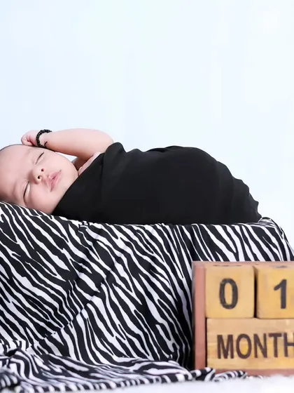 A clean and simple setup for a one-month-old baby, swaddled and resting peacefully. The focus remains entirely on the baby's serene presence.