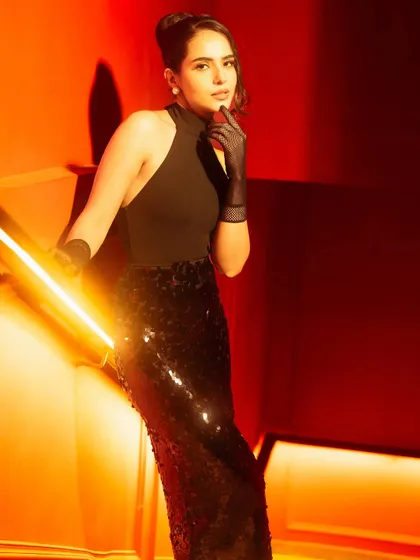 This shot is a study in using warm tungsten tones and a low key light to create drama. I teach how to use camera angles and sculpted light to elongate the frame and enhance textures like the sequins on the skirt.