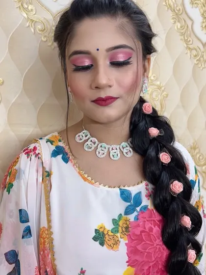 A close-up of the pink eye makeup and the rose-adorned braid.