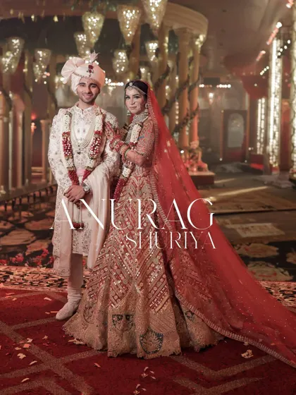 A grand portrait of the couple in their stunning red and white wedding attire.
