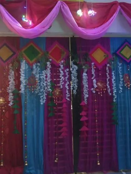 A house gate decorated with colorful drapes and hanging props, creating a welcoming entrance for guests.