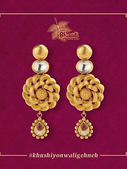 The perfect blend of elegance and simplicity. These lightweight earrings feature intricate floral-patterned gold discs, topped with a Kundan stone and finished with a ruby drop, effortlessly elevating any look.