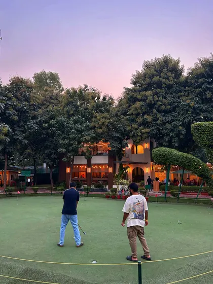 As dusk settles, the putting green becomes a beautiful spot for guests to mingle and play during an evening event.