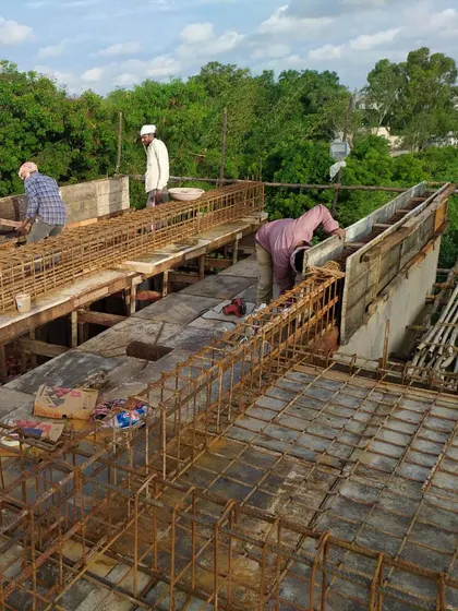 Workers on site preparing the reinforcement for the concrete slab. This image provides a glimpse into the hands-on process of building and the labor that goes into creating these complex structures.