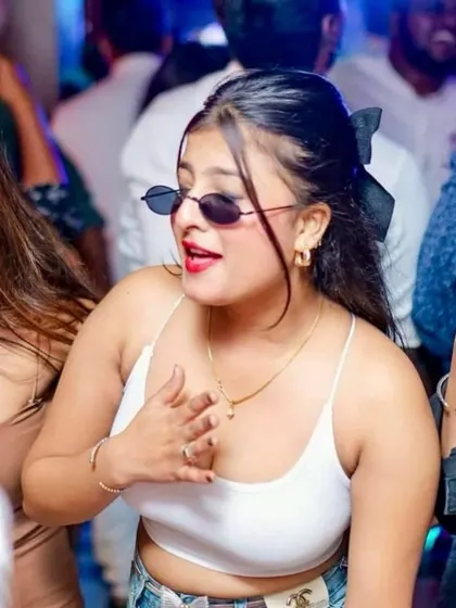 A partygoer with cool shades and a great vibe, enjoying the music at DRAVA Bar & Kitchen. The crowd's style adds to the atmosphere.