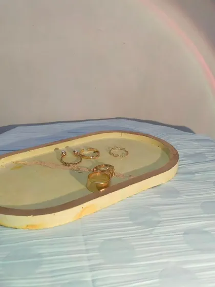 This is another trinket tray in a warm yellow marble finish. It's a versatile piece that can be used to hold jewelry, keys, or other small everyday items.