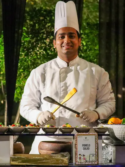 A chef at the Pomelo Salad station, posing proudly with his tools. Our team is not just skilled; they are also warm and engaging, enhancing the guest experience at our live stations.