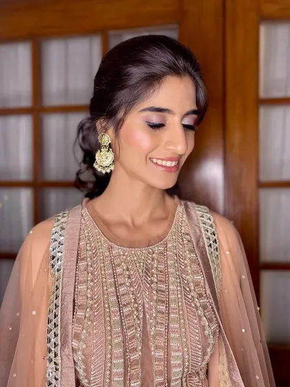 Soft glam goals. A dewy, radiant look with a touch of blush pink eyeshadow and a nude lip, finished with a sleek bun.