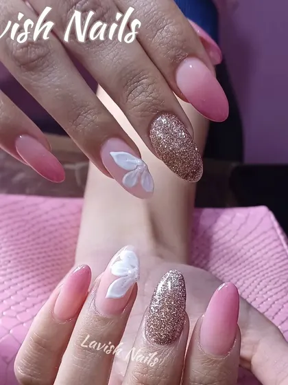 A beautiful combination of pink ombré and gold glitter nails, with a delicate 3D white flower on the ring finger for a soft, romantic touch.