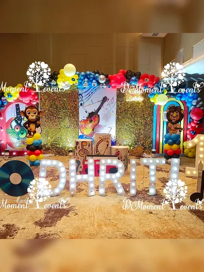 The full music-themed stage with light-up letters, character cutouts, and a backdrop filled with musical imagery.
