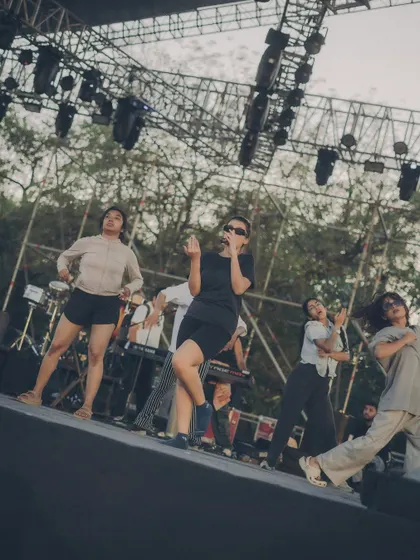The team running through the choreography on stage during a daytime rehearsal, getting a feel for the space.