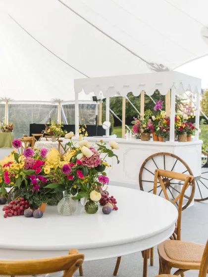 The English countryside Mehendi, filled with lush, colorful florals, comfortable lounge seating with bright pink cushions, and charming wicker details.