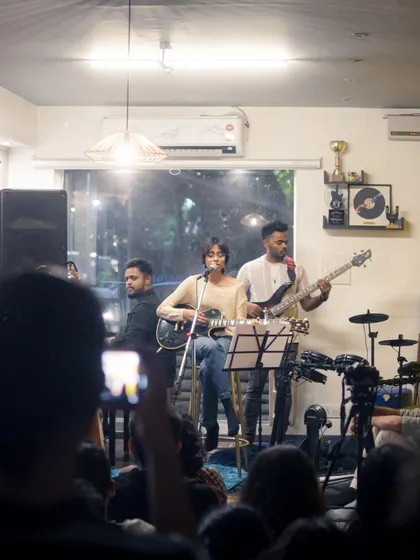 A wide shot of a band performing to a full house. This view captures the complete experience: the band, the audience, and the vibrant atmosphere of our venue.