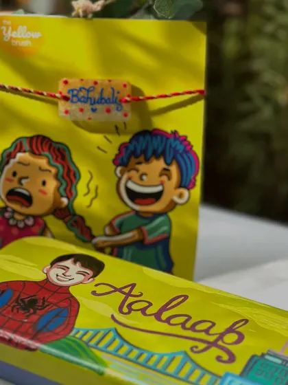 Another fun Rakhi combo, pairing a Spiderman-themed pencil box with a 'Bahubali' Rakhi.