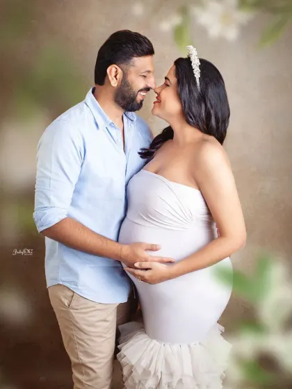 A close up, romantic shot that focuses on the couple's happy expressions. The soft, dreamy background adds to the magical feel of this maternity photo.