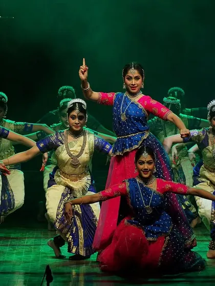 My sister Spurthi and I leading the ensemble in a fusion dance. This formation highlights the lead dancers while still maintaining the power and unity of the group, creating a multi-layered stage picture.