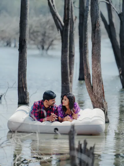 The reflection of the trees in the water adds to the serene beauty of this unique floating mattress photoshoot.