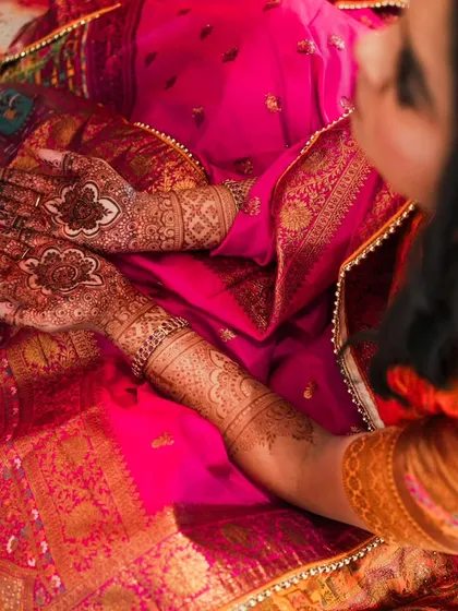 An overhead shot showing a lovely henna design on both hands, perfect for a guest at a wedding or for a festive celebration.