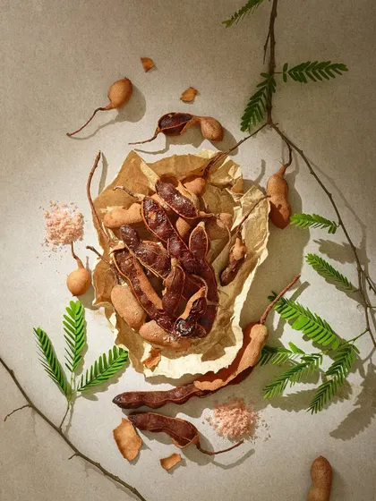 This shot is all about texture. From the brittle tamarind pods to the crumpled paper and scattered salt, every element is arranged to create a rustic and authentic feel for this nostalgic snack.
