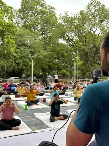 An instructor guides a large group through a pranayama technique. Clear guidance is key in our classes, ensuring everyone can follow along and receive the full benefits of the practice.