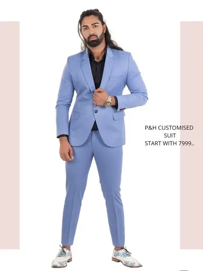 A full-length view of a custom two-piece suit in a striking sky blue, paired with a black shirt for a modern, contrasting look.