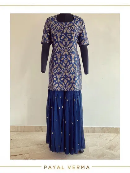 A unique combination of a pure Banarasi silk shirt paired with a georgette hand-embroidered gharara. This outfit blends rich texture with flowing fabric for a modern ethnic look.
