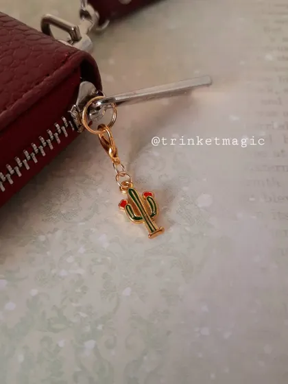 The cactus charm again, this time attached to a wallet zipper, showing how it can be used as a fun accessory.