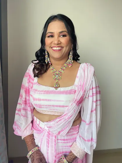 A big, happy smile from the mother of the bride. The makeup is fresh and glowing, making her look youthful and radiant.
