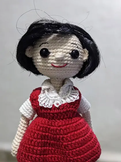 A close-up of a custom doll made as a gift for a 'jija' (sister-in-law), featuring a lovely red dress with a delicate lace collar.