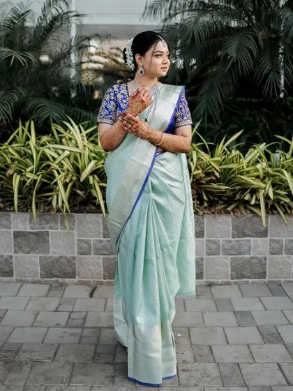 A full-length shot of the bride in her elegant saree. The soft makeup and classic hairstyle complete this beautiful and traditional look.