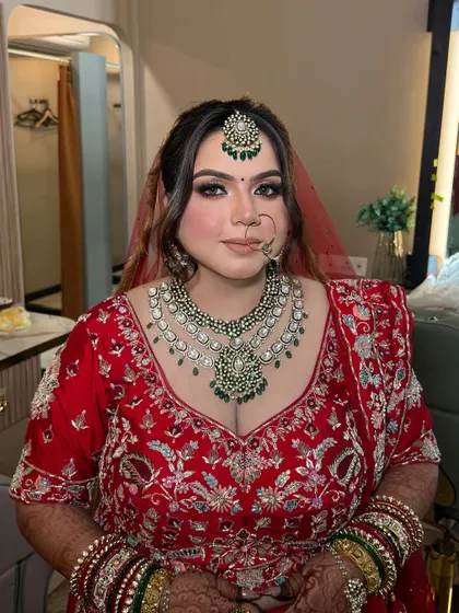 A closer look at this bride's glamorous makeup. The heavy kundan and emerald jewellery is balanced with a strong eye look and a perfectly sculpted face.