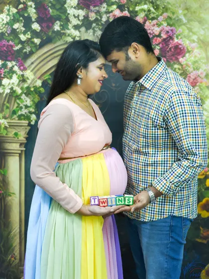 A sweet couple's portrait, holding "TWINS" blocks to celebrate their double blessing.