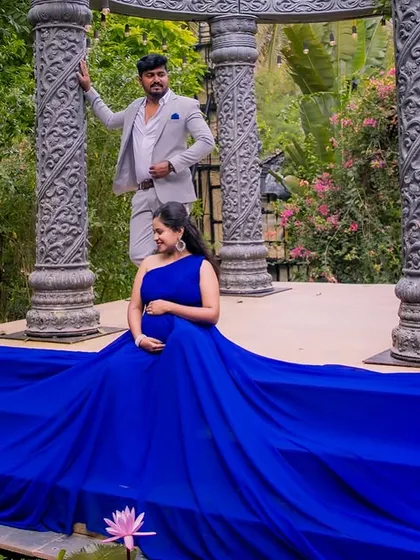 Another creative use of the flowing gown, this time draped over stone steps by a water feature. This pose creates an elegant, regal look for the mom-to-be in her maternity portrait.