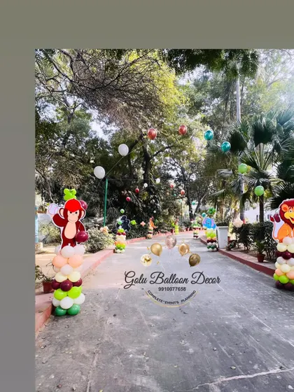 The entrance path to an outdoor jungle party, lined with animal character cutouts and balloon decorations.