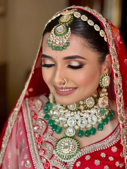 A close-up on the eyes. This shot showcases the soft, shimmery eyeshadow and the beautiful emerald tones in her jewelry, creating a look of understated elegance.