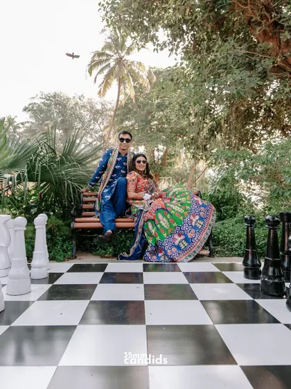 Love is the ultimate game of trust and togetherness. A creative shot of the couple at their Mehendi, seated by a giant chessboard, adding a playful and artistic touch.
