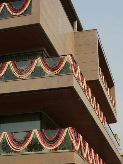 Another angle of the building's exterior, where the festive floral garlands create a beautiful contrast against the modern stone facade.