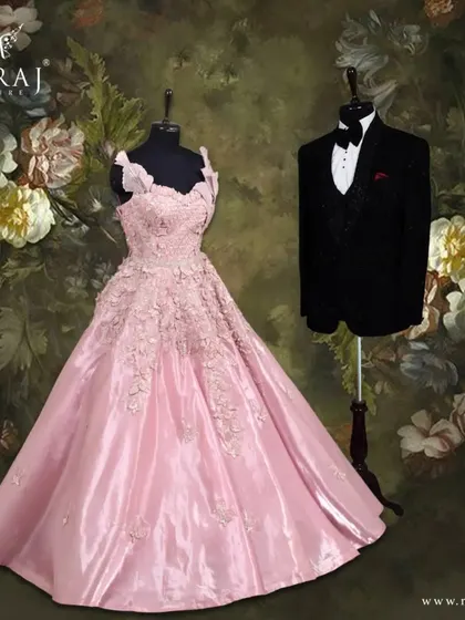 Unveiling the magic of peach and black. The groom's classic black tuxedo with a self-embossed design provides a timeless anchor to the bride's exquisite peach gown with floral appliqué.