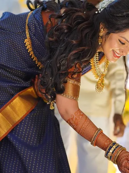 This shot captures the elegance of the bride's traditional attire and her joyful expression, enhanced by a soft and natural makeup application.