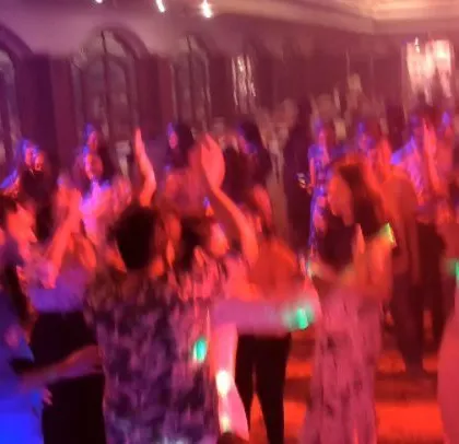 The party goes on, with guests in Hawaiian shirts enjoying the music.