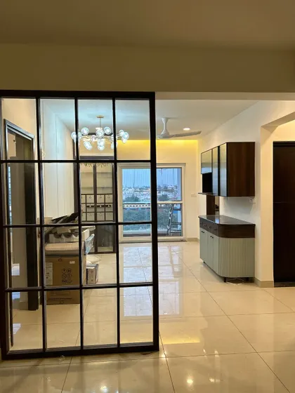 Sleek design meets craftsmanship. A view of a modern living space through a black metal and glass partition, showing our attention to creating distinct zones.
