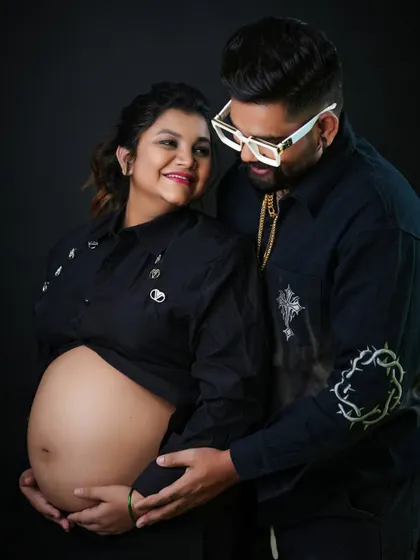 A loving couple's portrait with a focus on the bare belly. The shared look between them speaks to their partnership and excitement on this journey together.