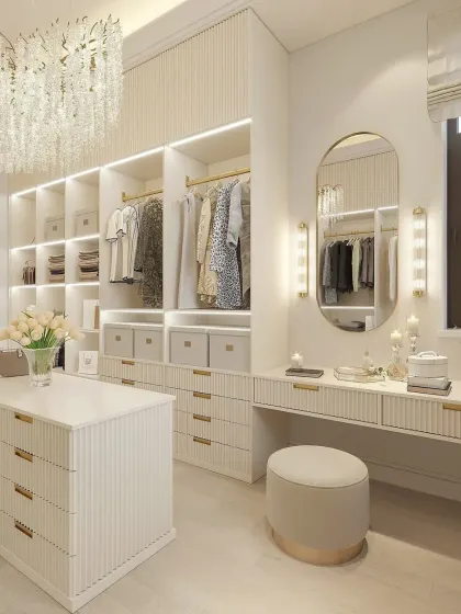 This view captures the full scope of the bright walk-in closet, from the crystal chandelier to the well-organized shelving and vanity area.
