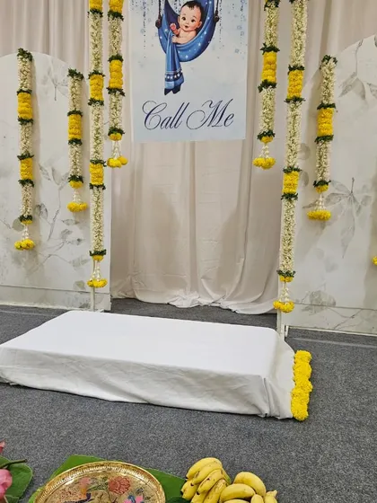 This view shows the ceremonial space on the floor, set up with banana leaves, flowers, and fruits. We ensure every part of the event space, from the backdrop to the ritual area, is thoughtfully decorated.