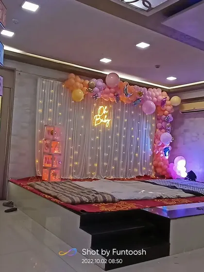 A wide view of a simple yet elegant 'Oh Baby' themed stage decoration in a banquet hall, ready for the ceremony.