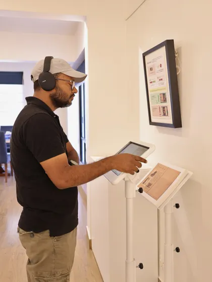 A visitor uses headphones to immerse themselves in the audio-visual component of the Raja Ravi Varma AR experience, demonstrating our commitment to multi-sensory art encounters.